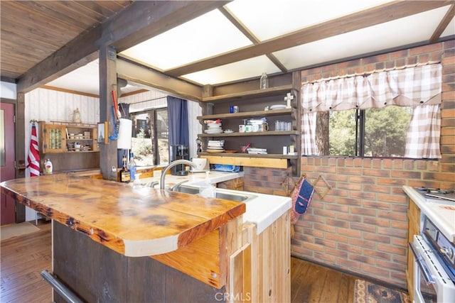interior space with hardwood / wood-style floors, beam ceiling, and brick wall
