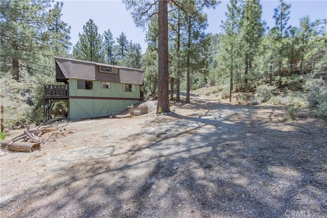 exterior space with a wooden deck and driveway