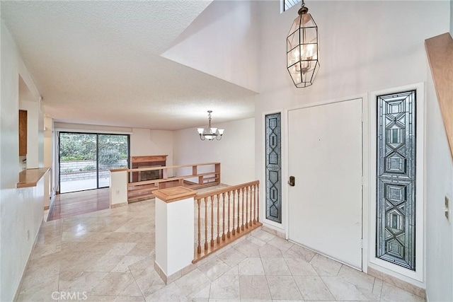 entryway with an inviting chandelier and a textured ceiling