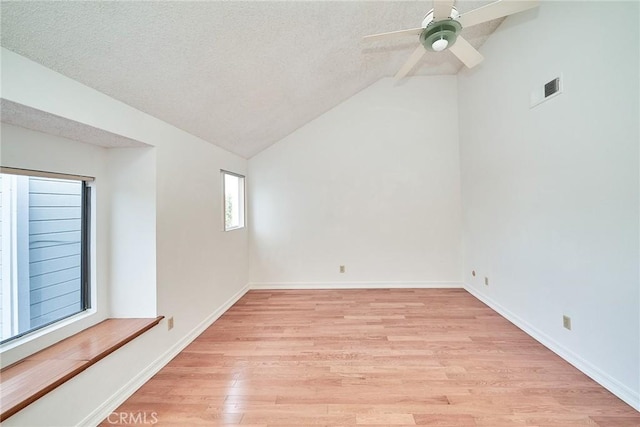 unfurnished room with a ceiling fan, a textured ceiling, visible vents, vaulted ceiling, and light wood-type flooring