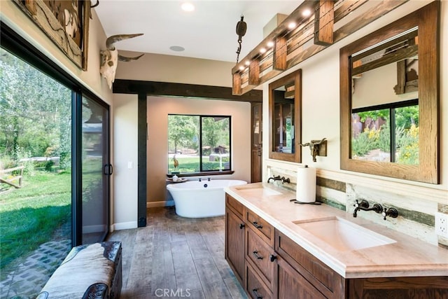 37547 Oak Glen Rd, Oak Glen, CA 92399 - bathroom with double vanity, a sink, a freestanding tub, and hardwood / wood-style flooring