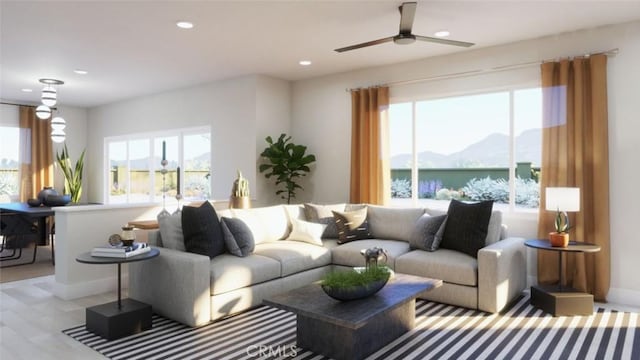 living area with a mountain view, ceiling fan, recessed lighting, and baseboards