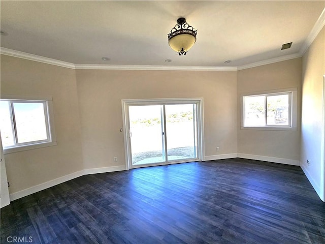 spare room with a healthy amount of sunlight, crown molding, dark wood finished floors, and baseboards