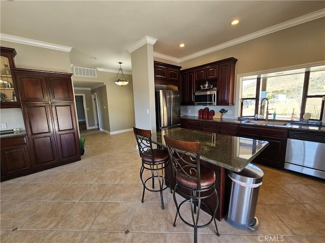 kitchen featuring a breakfast bar, stainless steel appliances, ornamental molding, a sink, and light tile patterned flooring