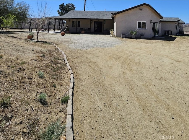 rear view of house featuring stucco siding