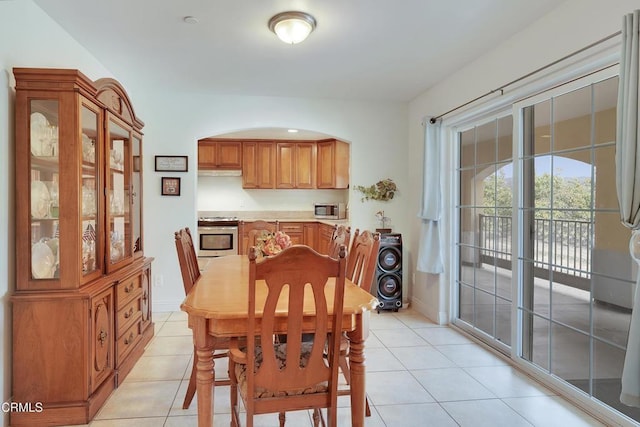 dining room with light tile patterned floors and arched walkways