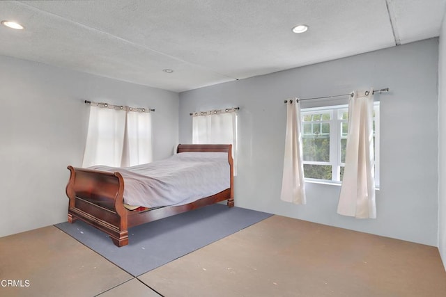 bedroom with concrete floors and recessed lighting