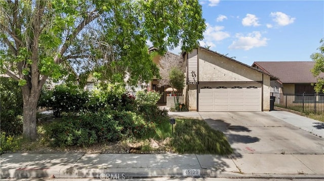 45109 18th St W, Lancaster, CA 93534 - view of front facade featuring fence, an attached garage, driveway, and stucco siding
