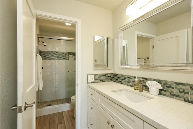999 N Pacific St Unit E108, Oceanside, CA 92054 - bathroom with tasteful backsplash, wood finished floors, a shower stall, toilet, and vanity