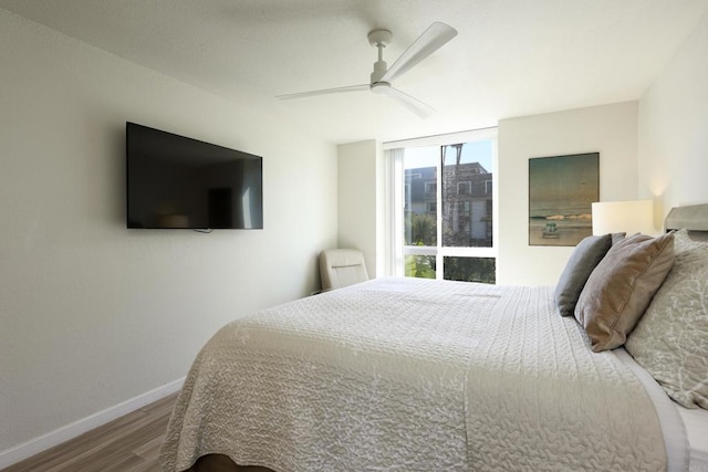 999 N Pacific St Unit E108, Oceanside, CA 92054 - bedroom featuring wood finished floors, a ceiling fan, and baseboards
