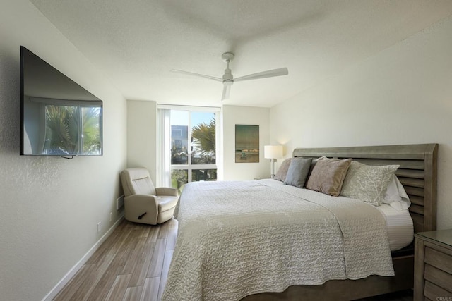 999 N Pacific St Unit E108, Oceanside, CA 92054 - bedroom with wood finished floors, a ceiling fan, and baseboards