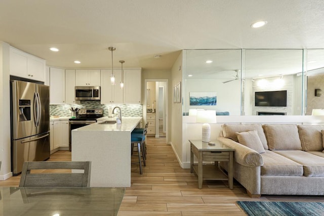 999 N Pacific St Unit E108, Oceanside, CA 92054 - kitchen featuring white cabinetry, baseboards, open floor plan, and appliances with stainless steel finishes