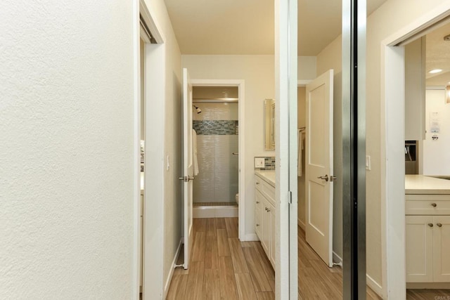 999 N Pacific St Unit E108, Oceanside, CA 92054 - corridor with light wood-style floors and baseboards