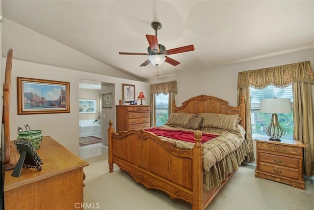 bedroom with lofted ceiling, a ceiling fan, light colored carpet, and connected bathroom