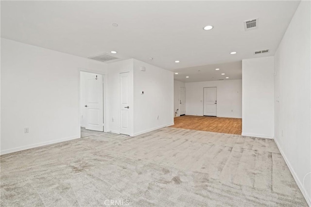 carpeted empty room with recessed lighting, visible vents, and baseboards