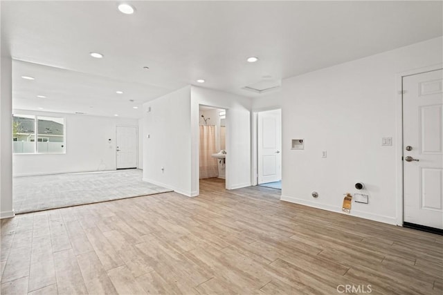 unfurnished living room with recessed lighting, light wood-style flooring, and baseboards