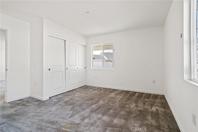 unfurnished bedroom featuring a closet, carpet, and baseboards