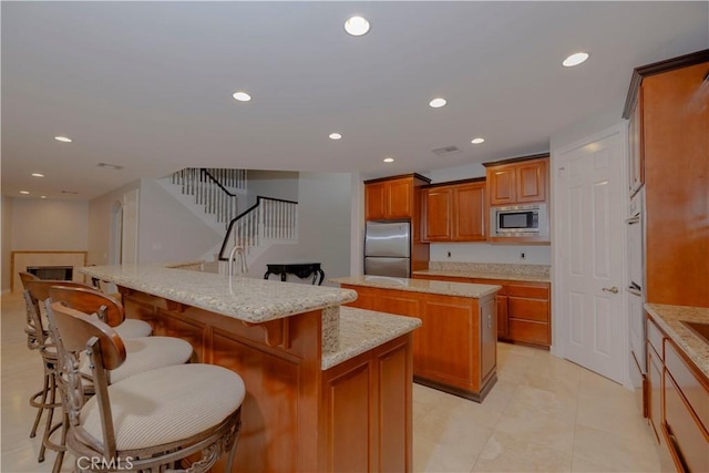 29515 Longhorn Dr, Canyon Lake, CA 92587 - kitchen with stainless steel appliances, a large island, brown cabinets, a kitchen bar, and recessed lighting