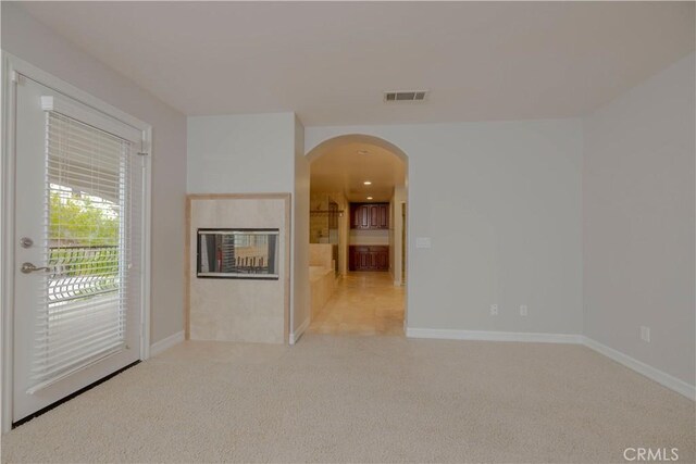 29515 Longhorn Dr, Canyon Lake, CA 92587 - unfurnished room with arched walkways, light colored carpet, a multi sided fireplace, and baseboards