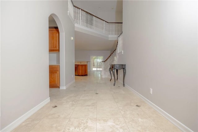 29515 Longhorn Dr, Canyon Lake, CA 92587 - corridor with stairway, a towering ceiling, arched walkways, and baseboards