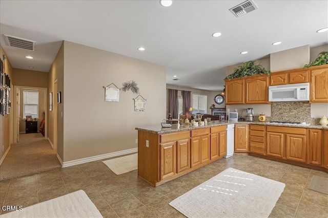 kitchen with recessed lighting, white microwave, and visible vents