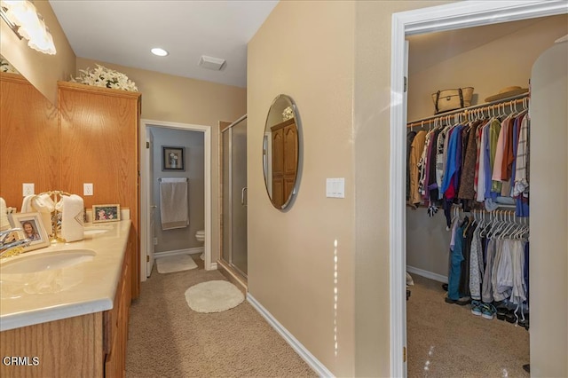 full bath with a walk in closet, vanity, visible vents, and a shower stall