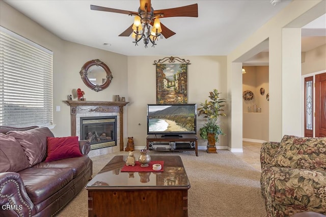 living room with carpet flooring, a fireplace, baseboards, and ceiling fan