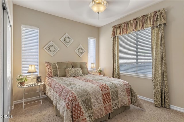 carpeted bedroom featuring baseboards and a ceiling fan