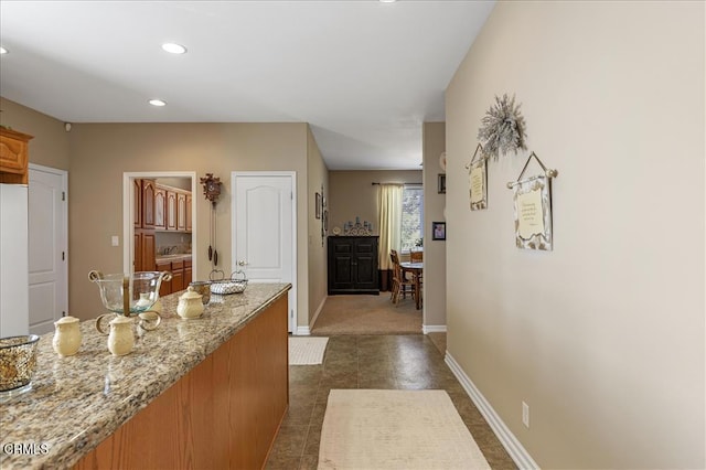 hallway featuring a sink, baseboards, and recessed lighting