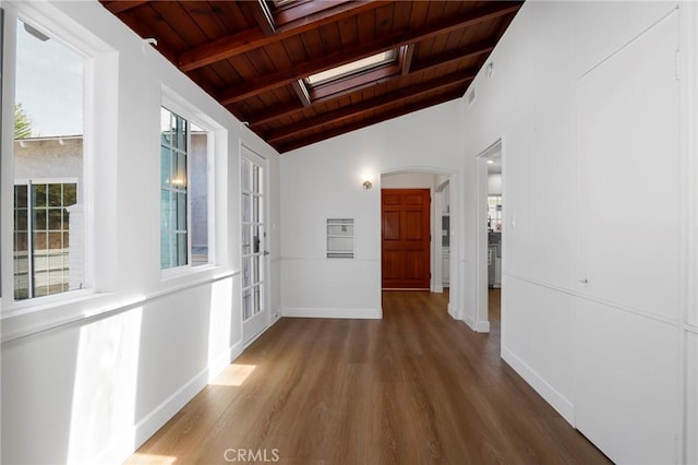 corridor featuring arched walkways, vaulted ceiling with skylight, wood finished floors, and wood ceiling