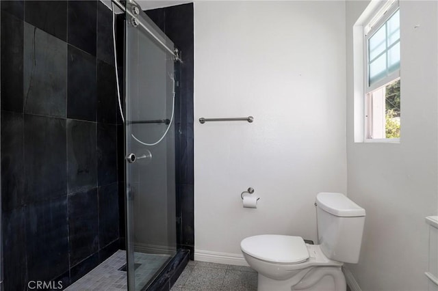 full bathroom with baseboards, a shower stall, and toilet