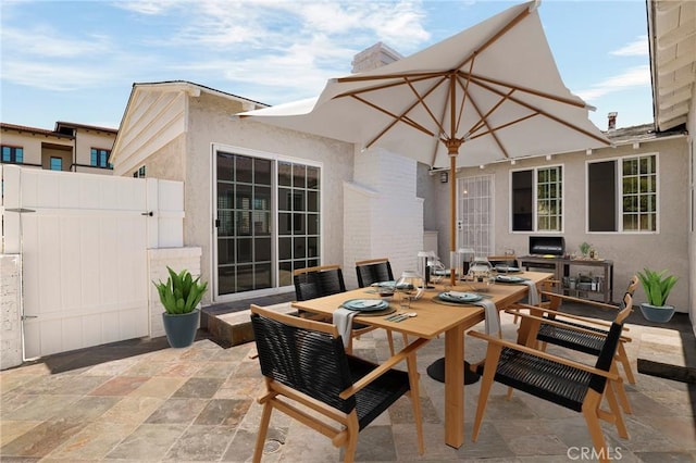 view of patio featuring fence, a gate, and outdoor dining area