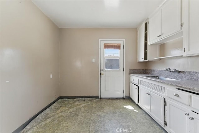kitchen featuring a sink, open shelves, baseboards, light countertops, and white cabinets