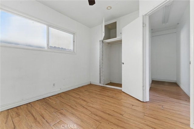 unfurnished bedroom with a ceiling fan, light wood-style flooring, and baseboards