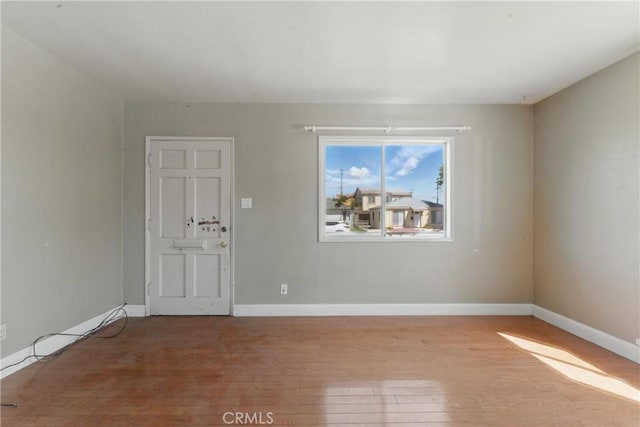 spare room featuring wood finished floors and baseboards