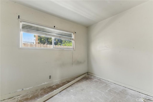 unfurnished room featuring baseboards
