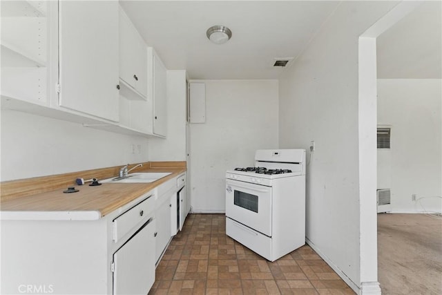 kitchen featuring a sink, white gas range, visible vents, white cabinetry, and light countertops
