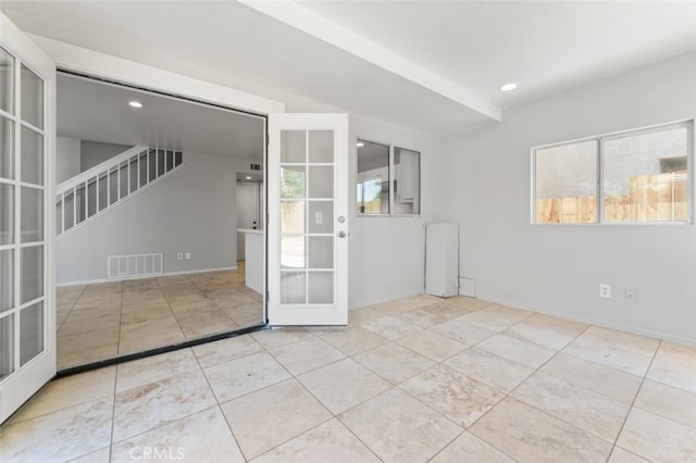 empty room with tile patterned floors, visible vents, french doors, and baseboards