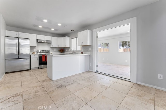 kitchen featuring recessed lighting, under cabinet range hood, appliances with stainless steel finishes, light countertops, and a sink