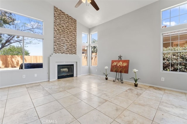 unfurnished living room with high vaulted ceiling, a ceiling fan, tile patterned flooring, and plenty of natural light