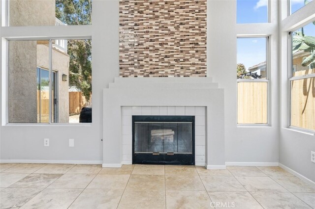details with a tiled fireplace and baseboards