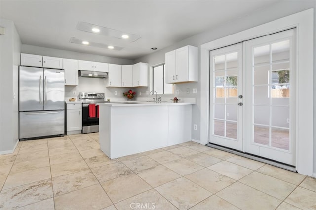 kitchen featuring recessed lighting, stainless steel appliances, under cabinet range hood, a sink, and french doors