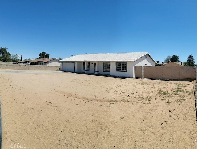 back of property featuring a garage and fence
