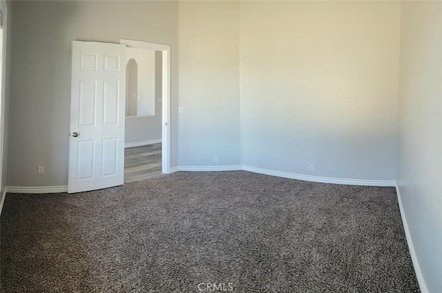 spare room featuring baseboards and carpet flooring