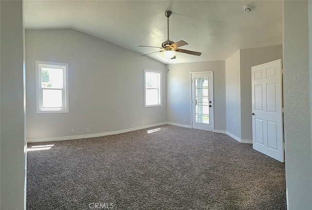 carpeted empty room featuring vaulted ceiling, baseboards, a ceiling fan, and visible vents
