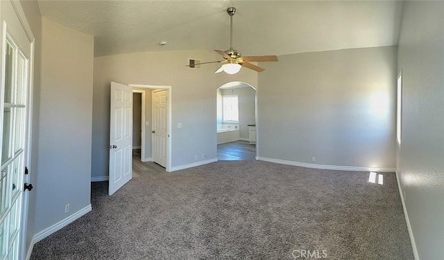 unfurnished bedroom with ceiling fan, arched walkways, vaulted ceiling, baseboards, and carpet