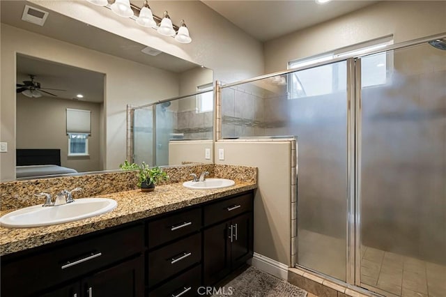 bathroom featuring a sink, a ceiling fan, a stall shower, and connected bathroom