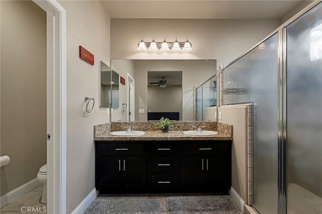 full bathroom featuring a ceiling fan, a sink, a stall shower, and toilet
