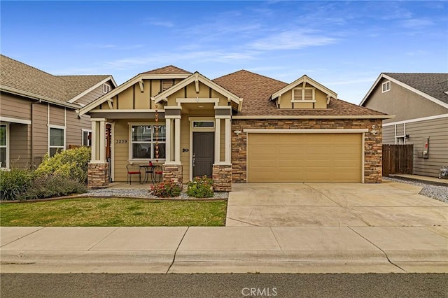 craftsman-style home featuring stone siding, a garage, board and batten siding, concrete driveway, and covered porch