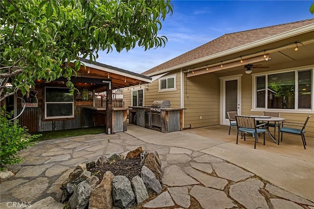 view of patio featuring a ceiling fan, outdoor dining space, and an outdoor kitchen